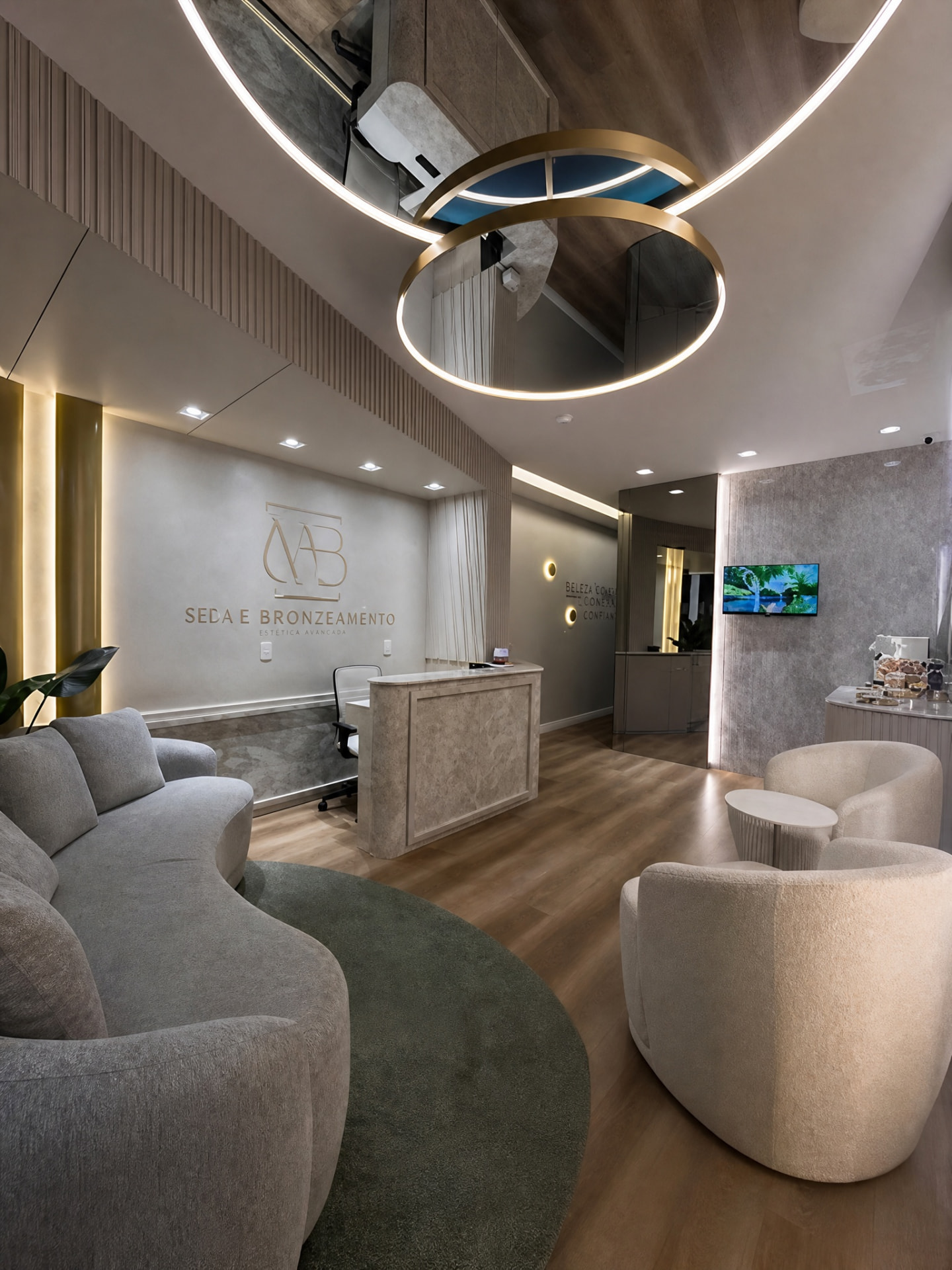 Recepção sofisticada do Master Bronze SPA com móveis modernos, iluminação dourada e logo na parede